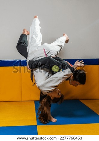 Young girl and boy practice Brazilian jiu jitsu in the gym