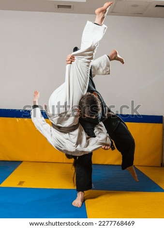 Young girl and boy practice Brazilian jiu jitsu in the gym Royalty-Free Stock Photo #2277768469