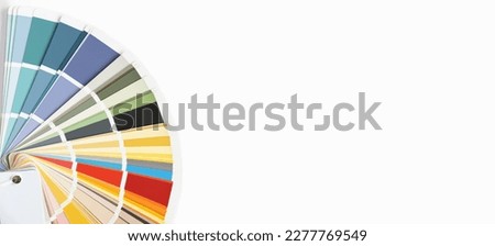 Color guide close up. Assortment of colors for design. Colors palette fan on a white concrete wall background. Graphic designer chooses colors from the color palette guide. Coloured swatches catalogue Royalty-Free Stock Photo #2277769549