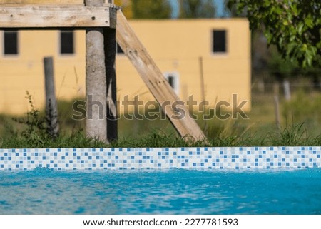A pool with a wooden ladder next to it