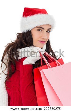 Pretty brunette in winter wear holding shopping bags on white background