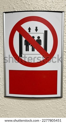 Warning sign: Do not use elevators during fire. Red prohibition sign at the top of the elevator on a white background