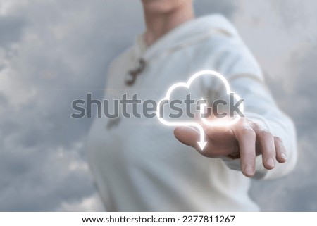 The concept of data exchange on the Internet. A woman clicks on the button for receiving and transmitting data against the sky.
