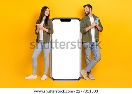 Full size picture of two people have feelings for each other stand near huge phone display placard isolated on yellow color background