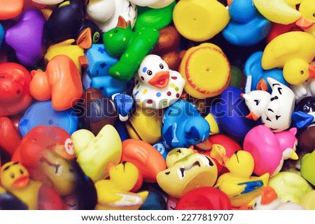 Top view of various colorful bath rubber plastic ducks. One duck facing and looking at camera. Design element. Uniqueness and leadership concept.