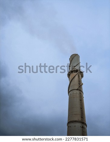 Corporate chimneys against a cloudy sky background