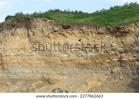 Sedimentary rocks with a high content of iron oxide. Red soil, loam. The texture of the soil. Royalty-Free Stock Photo #2277862663