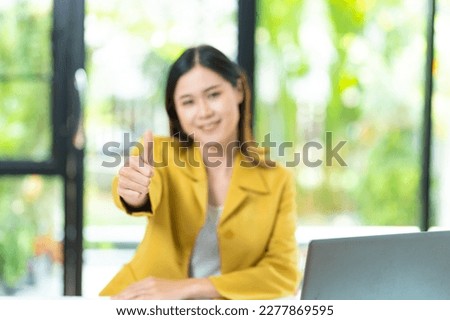 Young woman using laptop computer making happy thumbs up gesture with hand approving expression at camera with showing success.