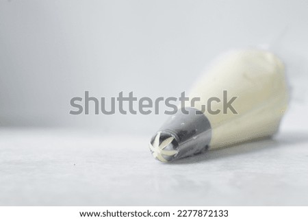 Buttercream in a piping bag, American buttercream in a piping bag for icing cake, frosting for decorating cake Royalty-Free Stock Photo #2277872133