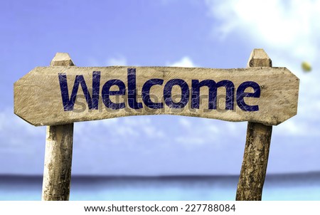Welcome wooden sign with a beach on background