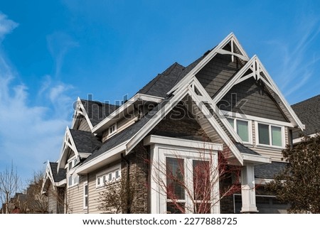Roof shingles on top of the house against blue sky. Dark asphalt tiles on the roof background. black shingles, roof tile. Nobody, Selective focus, street photo, copy space. Royalty-Free Stock Photo #2277888725
