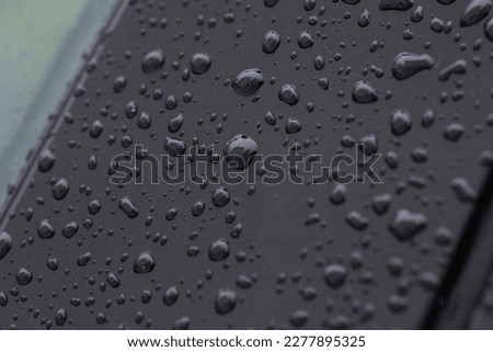 Raindrops on black metalic surface backdrop