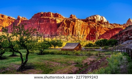 Barn in a meadow surrounded by red sandstone mountains in the Fruita settlement in Capitol Reef National Park, Utah, USA Royalty-Free Stock Photo #2277899243