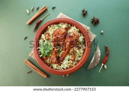 Chicken biryani Spicy Indian Malabar Hyderabadi biryani. Dum Biriyani pulao in red clay pot Kerala India Sri Lanka. Pakistan basmati rice mixed rice dish with meat curry Ramadan Kareem Eid Easter Royalty-Free Stock Photo #2277907153