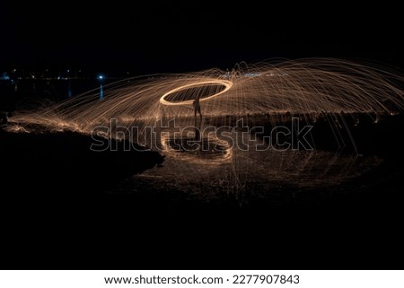Showers of hot glowing sparks from spinning steel wool.  Royalty-Free Stock Photo #2277907843