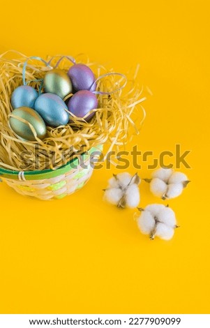 Multicolored Easter eggs in a basket on a bright orange festive background. Happy easter.Greetings and presents for Easter Day celebrate time. Flat lay ,top view.
