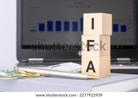 IFA - short for Institute of Financial Accountants. text on wood cubes with euro bills. front view