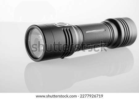 LED black flashlight close-up on white background, trace of bright light. High quality photo
