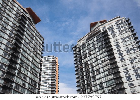 Modern highrise building or tall residential towers with blue sky. Group of tall glass buildings. Empty homes tax, speculation tax or gentrification concept. Vancouver, BC, Canada. Selective focus. Royalty-Free Stock Photo #2277937971