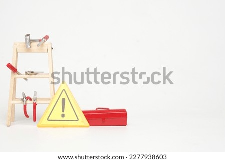 A picture of handyman tools, ladder, toolbox and hazard sign on white background