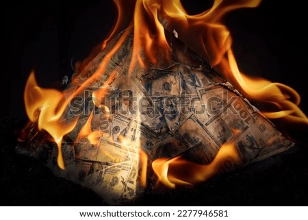 A global financial pyramid based on the dominance of the dollar. World management concept. conspiracy theory. the collapse of the dollar's financial system. Money is burning on a dark background. Royalty-Free Stock Photo #2277946581