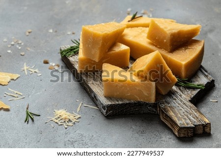 Sliced and grated parmesan cheese with rosemary on a gray table, banner, menu, recipe place for text, top view. Royalty-Free Stock Photo #2277949537