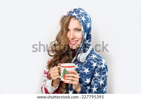 Beauty woman in colorful pajamas drinking hot tea over light gray background