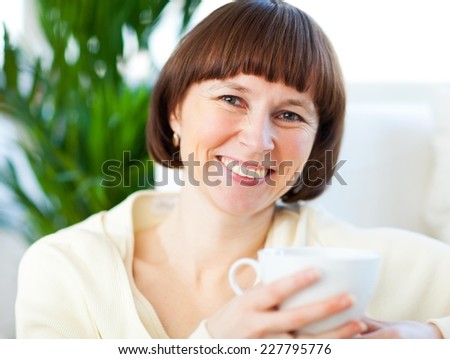 Beautiful woman drinking tea at home.