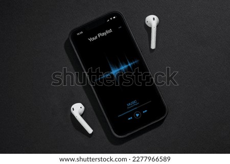 Smartphone with music player app on dark grey background Royalty-Free Stock Photo #2277966589