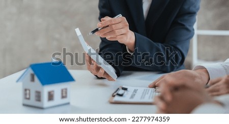 Happy couple signing a contract with real estate agent. renters tenants sign mortgage loan investment agreement or rental insurance contract meeting realtor lender landlord making real estate sale Royalty-Free Stock Photo #2277974359