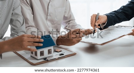 Happy couple signing a contract with real estate agent. renters tenants sign mortgage loan investment agreement or rental insurance contract meeting realtor lender landlord making real estate sale