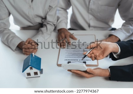 Happy couple signing a contract with real estate agent. renters tenants sign mortgage loan investment agreement or rental insurance contract meeting realtor lender landlord making real estate sale