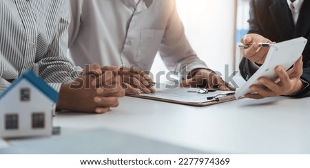 Happy couple signing a contract with real estate agent. renters tenants sign mortgage loan investment agreement or rental insurance contract meeting realtor lender landlord making real estate sale Royalty-Free Stock Photo #2277974369