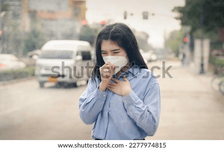 Asian woman wearing the N95 Respiratory Protection Mask against PM2.5 air pollution and headache Suffocate. City air pollution concept Royalty-Free Stock Photo #2277974815