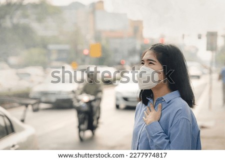 Asian woman wearing the N95 Respiratory Protection Mask against PM2.5 air pollution and headache Suffocate. City air pollution concept Royalty-Free Stock Photo #2277974817
