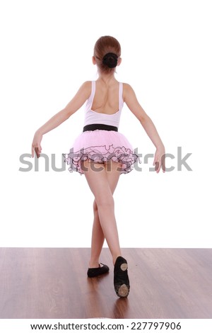 Elegant little ballerina in a pink tutu standing back to camera isolated on white