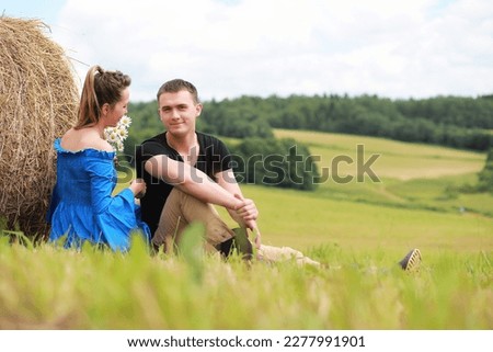 couple in love in a village field at sunset
