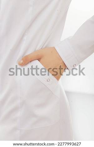 Cropped close up details of medical scrubs clothes. Beautiful young female model. White studio background. Catalog photo shoot in minimalist style Royalty-Free Stock Photo #2277993627