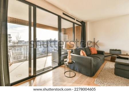a living room with sliding glass doors that open to the balcony and patio area in the room is furnished for entertaining