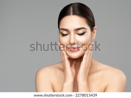 Beauty Face Skin Care. Woman with Full Lips Natural Makeup over isolated background. Beautiful Model enjoying Spa Massage. Facial Plastic Surgery and Dermal Filler Cosmetology Royalty-Free Stock Photo #2278015439