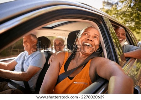 Group Of Senior Friends Enjoying Day Trip Out Driving In Car Together