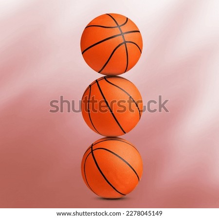 Stack of basketball balls on coral background
