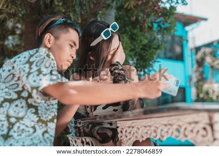 A young woman covers her face, refusing to take a picture with her boyfriend. Embarrassed and ashamed to be seen with her date. Royalty-Free Stock Photo #2278046859