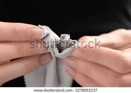 Jeweler cleaning diamond ring with microfiber cloth, closeup Royalty-Free Stock Photo #2278052137