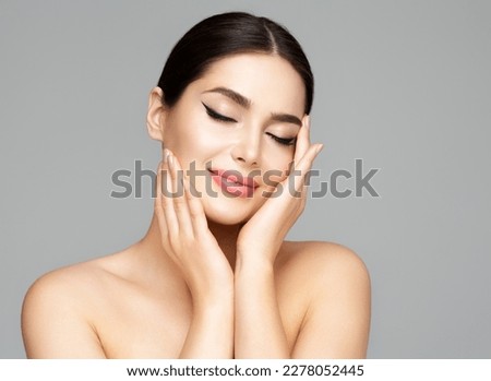 Woman Face Skin Care. Beauty Model holding Face in Hands. Beautiful Girl with Smooth Skin and Plump Lips Makeup over Gray. Facial Spa Cosmetology and Plastic Surgery Royalty-Free Stock Photo #2278052445