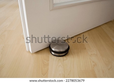 White door and door stopper on the wooden floor