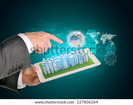 Man hands using tablet pc. Business city on touch screen. Earth near computer. Elements of tgis image furnished by NASA