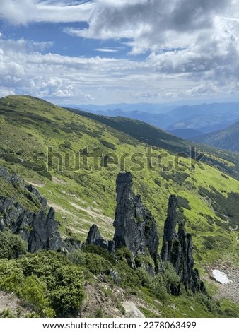 Mountainous countryside scenery at sunset. dramatic sky above the distant valley. Scenic sharp rocks in the mountains.