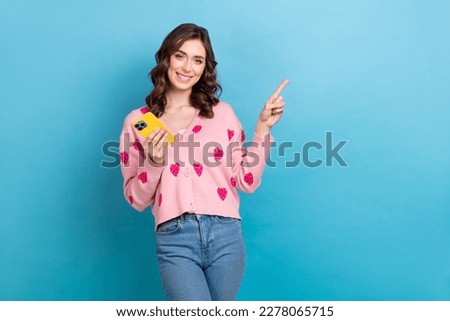 Photo portrait of lovely lady hold gadget point empty space dressed stylish pink strawberry print garment isolated on blue color background