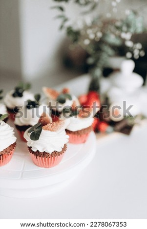 Confectioner prepares and decorates cupcakes with berries